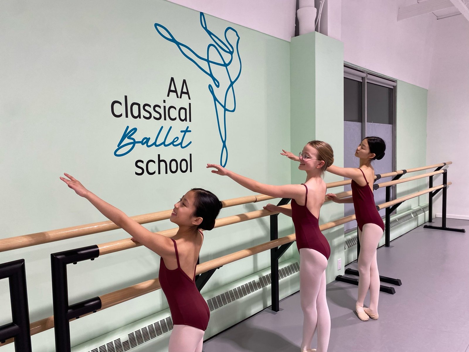 Young ballet students practicing at the barre during a children’s ballet class in Calgary.